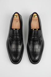 Black leather textured loafers with elegant design for formal occasions.